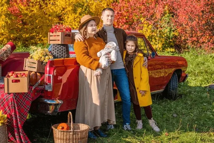 Family wearing vibrant fall outfits in warm autumn colors, creating a stylish and eye-catching look for a seasonal outdoor photoshoot.